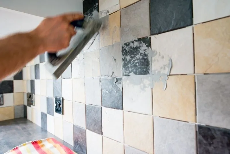 Tiler applying grout to newly installed wall tiles in Noosa