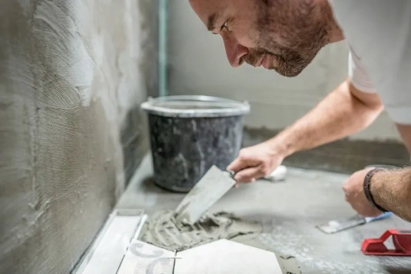Tiler installing kitchen floor tiles in a Noosa home