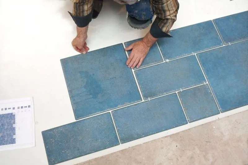 Installing square blue outdoor tiles on a Noosa patio