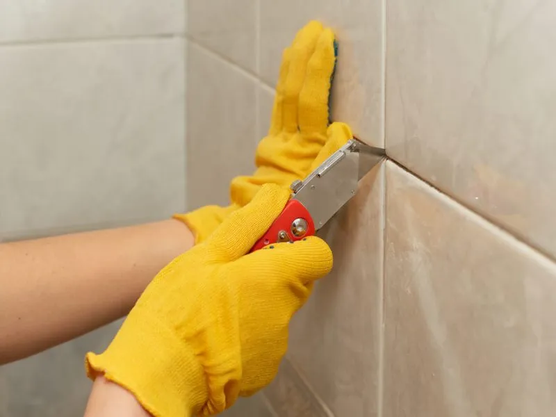 Removing old grout between tiles with a utility knife