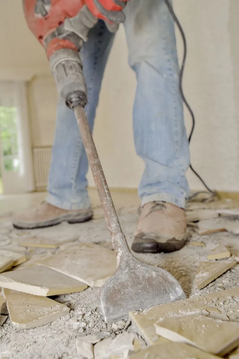 removing floor tiles with a jackhammer and a chisel bit